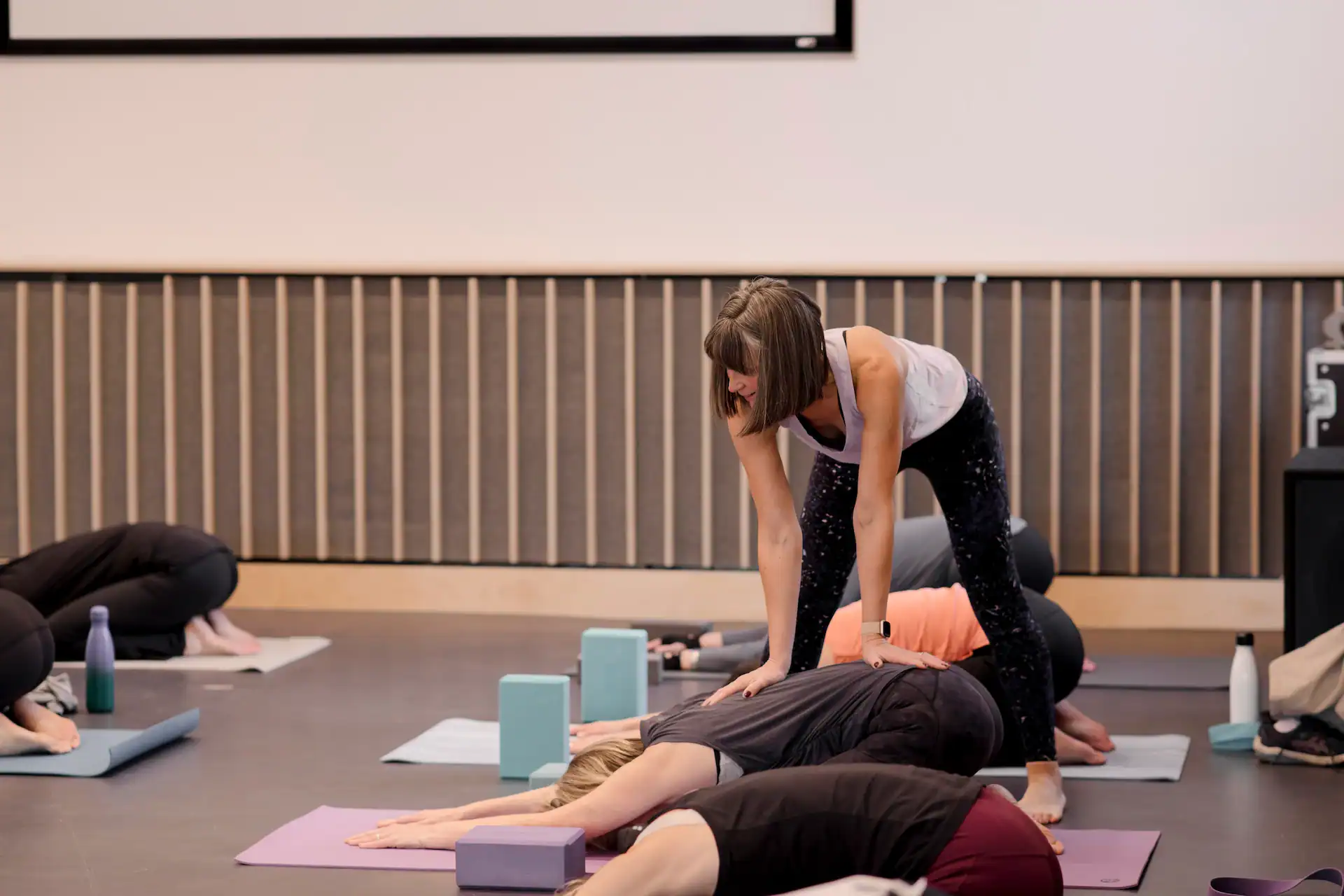 Pilates instructor assisting a student during a class session.
